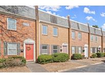 Charming brick townhouse with colorful doors, landscaping, and a well-maintained facade at 265 Winding River Dr # F, Atlanta, GA 30350