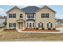 Two-story home with tan siding, stone accents, and a well-maintained front yard at 15 Streamside Dr, Covington, GA 30016