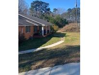 Charming brick home with a front porch and a well-maintained lawn at 1902 Godby Rd, Atlanta, GA 30349