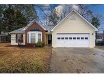 Charming single-story home featuring a bay window, brick facade, and attached two-car garage at 555 Burnham Rdg, Lawrenceville, GA 30046