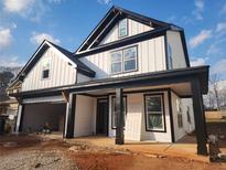 New two-story modern farmhouse featuring white siding, black trim, covered porch, and a two-car garage at 1064 Eastview Ne Rd, Conyers, GA 30012