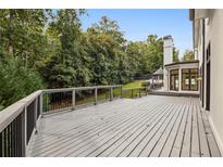 A spacious deck overlooks the well-maintained yard and mature trees at 725 Riley Pl, Sandy Springs, GA 30327