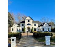 Stunning two-story home featuring a gated entrance, lush landscaping, and classic architectural details at 725 Riley Pl, Sandy Springs, GA 30327