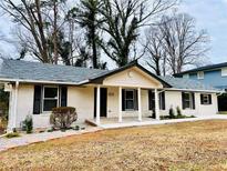 Charming single-story home featuring a brick facade, black shutters, and a welcoming front porch at , Decatur, GA 30032