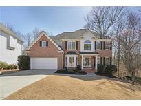Traditional brick home with manicured front lawn and attached two-car garage, perfect for suburban living at 1110 Croftmoore Lndg, Suwanee, GA 30024