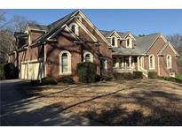 Charming brick home featuring a well-manicured lawn and a two-car garage at 589 Cook Dr, Ellenwood, GA 30294