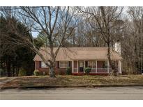 Charming brick home with inviting front porch and mature trees in a quiet neighborhood at 541 Exam Ct, Lawrenceville, GA 30044