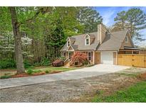 Charming home featuring an attached garage, dormer windows, mature trees, and a long driveway at 1765 Round Rd, Grayson, GA 30017