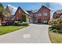 Stunning brick home features manicured landscaping and a long, elegant driveway leading to a two-car garage at 29 Cliftwood Dr, Sandy Springs, GA 30328