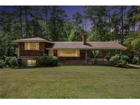 Charming home with a covered porch, a chimney, and a large front yard at 1007 E Callaway Sw Rd, Marietta, GA 30060