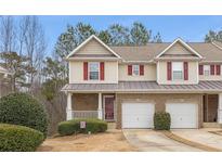 Inviting townhome with a brick facade, red shutters, and a well-maintained front yard at 144 Fox Creek Dr, Woodstock, GA 30188