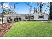 Charming home featuring a well-manicured lawn, neutral paint, and complemented by lush greenery and mature trees at 4770 Wayland Cir, Acworth, GA 30101
