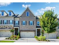 Charming brick townhome featuring a two-car garage and manicured landscaping at 11 Ganel Ln, Alpharetta, GA 30009