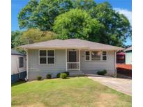 Charming single story home with a well-manicured front yard and driveway at 1857 Dunlap Ave, East Point, GA 30344