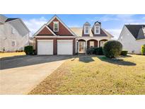 Charming brick home featuring a two-car garage, well-maintained lawn, and inviting front porch at 3296 Quincey Xing, Conyers, GA 30013