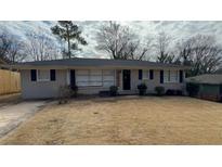 Charming single-story home with a well-maintained lawn and classic brick facade at 4027 Gladesworth Ln, Decatur, GA 30035