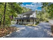 Charming two-story home with covered front porch, mature trees, and an American flag at 1700 Bailey Creek Sw Rd, Conyers, GA 30094