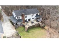 Aerial view of home featuring a large wooden deck, backyard, and wooded surroundings at 1700 Bailey Creek Sw Rd, Conyers, GA 30094