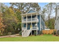 Charming two-story home boasts double porches, a blue facade, and a vibrant yellow front door at 1183 Mobile Nw St, Atlanta, GA 30314