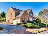 Charming brick home featuring an attached two-car garage and well-manicured front lawn at 3135 Preservation Cir, Lilburn, GA 30047