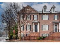 Charming brick townhome featuring a classic architectural style and well-maintained landscaping at 110 Rose Garden Ln, Alpharetta, GA 30009