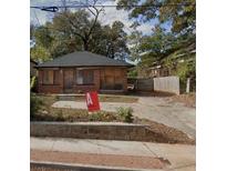 Modest brick house with boarded windows; 'A' sign in the yard at 837 Metropolitan Pkwy, Atlanta, GA 30310