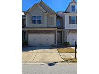 Charming two-story townhome featuring stone accents and a two-car garage at 2293 Chancery Mill Ln, Buford, GA 30519