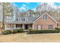 Charming brick home with a covered front porch and well-manicured landscaping at 1070 Thornwood Cir, Covington, GA 30016