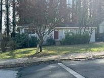 Charming single-story home features a well-kept lawn and inviting curb appeal in a serene, wooded setting at 3346 Delmar Nw Ln, Atlanta, GA 30331