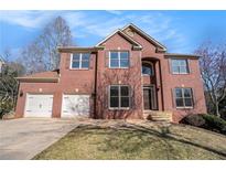 Charming two-story red brick home with a well-manicured lawn and attached two-car garage at 10950 Glenhurst Pass, Duluth, GA 30097