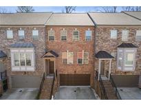 Attractive brick townhouse with attached garages, covered front doors, and well-maintained landscaping at 2710 Birch Grove Se Ln # 13, Marietta, GA 30067