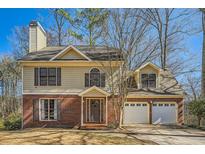 Charming two-story home with a brick and siding exterior, attached two-car garage, and a well-manicured front yard at 4727 Bradford Ln, Powder Springs, GA 30127