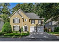 Charming two-story home featuring a well-manicured front yard, a two-car garage, and a classic architectural design at 4580 Windsor Park Place, Atlanta, GA 30342