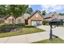 Charming brick home features a manicured lawn, stone accents and a two-car garage at 2110 Retreat Haven Ln, Dacula, GA 30019