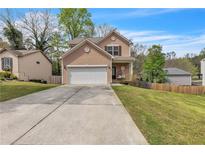 Charming two-story home with a two-car garage, well-manicured lawn, and inviting front porch at 4567 Hickory Forest Nw Dr, Acworth, GA 30102