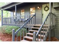 Charming home features a covered porch and staircase with a wreath-adorned front door at 5788 Stonehaven Nw Dr, Kennesaw, GA 30152