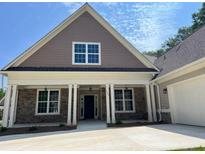 Inviting one-story home showcasing stone accents, a covered porch, and a convenient two-car garage at 117 Legends Way, Hiram, GA 30141