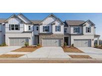 Charming townhomes featuring white exteriors, stone accents, and attached two-car garages at 2462 Bayberry St, Acworth, GA 30101
