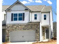 Two-story townhome featuring stone accents, a two-car garage, and a welcoming front entry at 2464 Bayberry St, Acworth, GA 30101