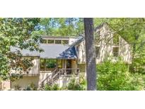 Charming home exterior with a welcoming front porch and stairway nestled among mature trees and lush greenery at 2755 Whitehurst Ne Dr, Marietta, GA 30062