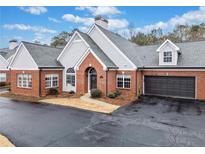 Charming brick home with gray siding, arched windows, attached garage and manicured landscaping at 140 Stonegate Ln, Canton, GA 30114