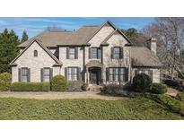 Traditional two-story brick home featuring a manicured lawn and well-maintained landscaping at 520 Waterside Ct, Canton, GA 30114