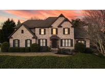 A charming two-story brick home with a well-manicured lawn and dark shutters at 520 Waterside Ct, Canton, GA 30114