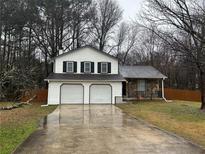 Charming home featuring a two-car garage, neutral siding, and a welcoming front yard at 1281 Bugle Ct, Hampton, GA 30228