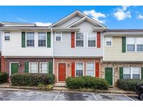 Charming townhome with red brick facade, colorful shutters, and well-maintained landscaping at 3610 Ginnis Rd # 4, Atlanta, GA 30331