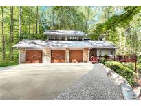 Secluded three-car garage home featuring stone accents and well-maintained landscaping at 4867 Township Trce, Marietta, GA 30066