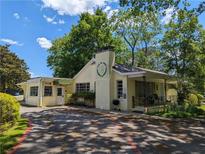Charming single-story building with a brick chimney and a covered front porch nestled among mature trees at 3941 Covered Bridge, Smyrna, GA 30082