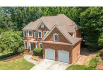 Beautiful two-story brick home with a well-manicured lawn and a two-car garage at 4085 Creekview Ridge Dr, Buford, GA 30518
