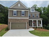 Two-story home features a brick and siding facade, attached garage, and a nicely manicured lawn at 508 Clayborne Way, Loganville, GA 30052