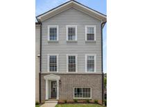 Charming two-story townhome exterior featuring gray siding, brick accents and white-framed windows at 3165 Dogwood Dr # 108, Hapeville, GA 30354